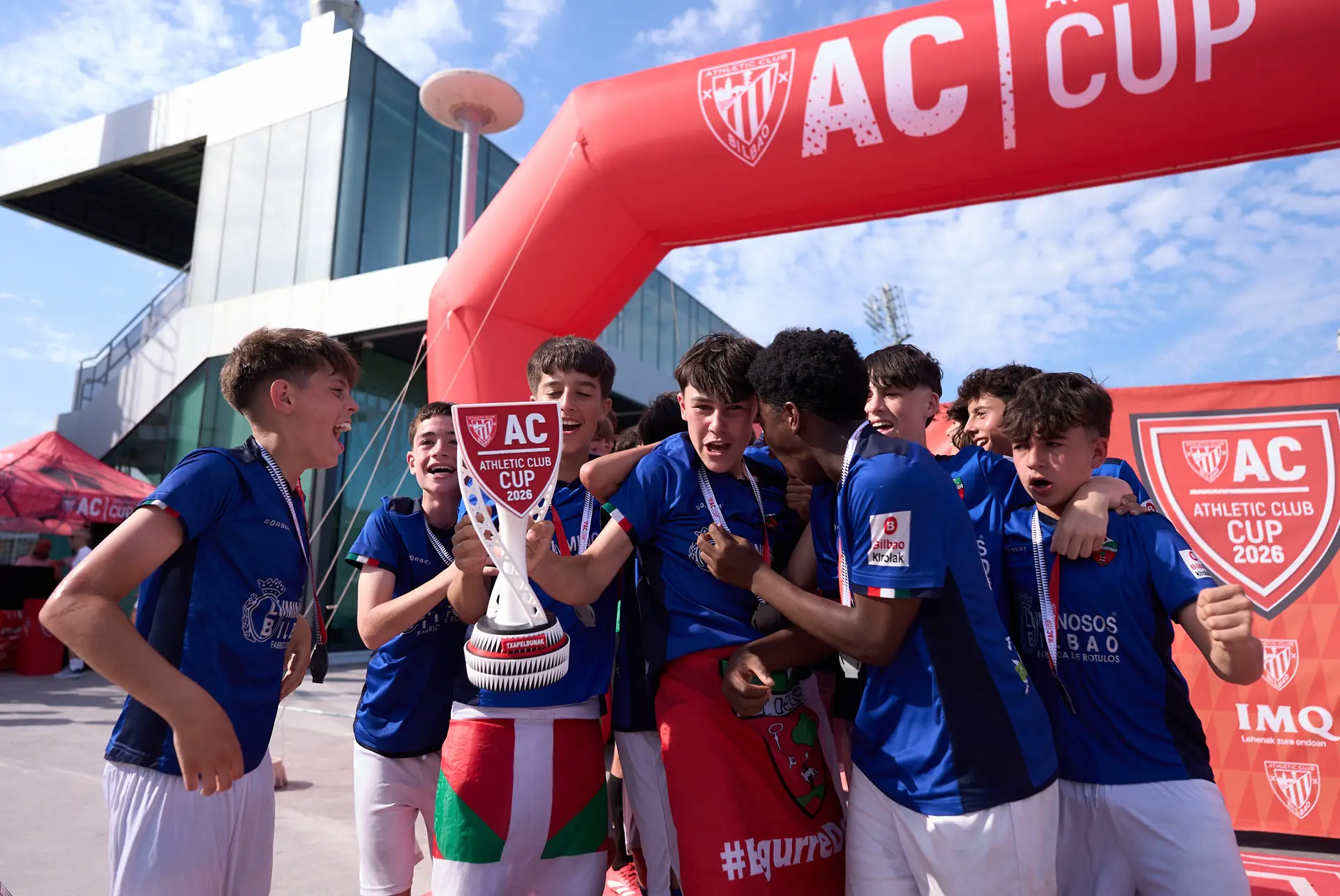 Un equipo celebra el trofeo bajo el arco de AC CUP